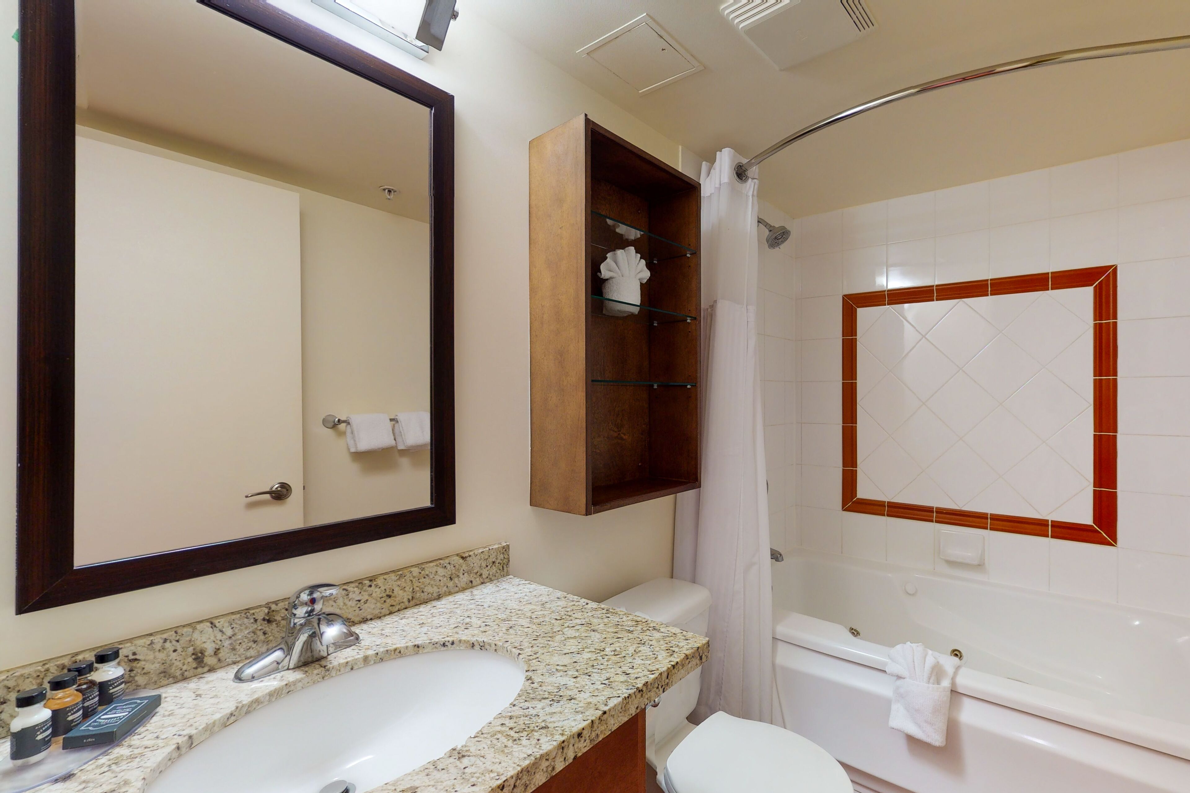 A bathroom with a sink, toilet, bathtub, and a large mirror.