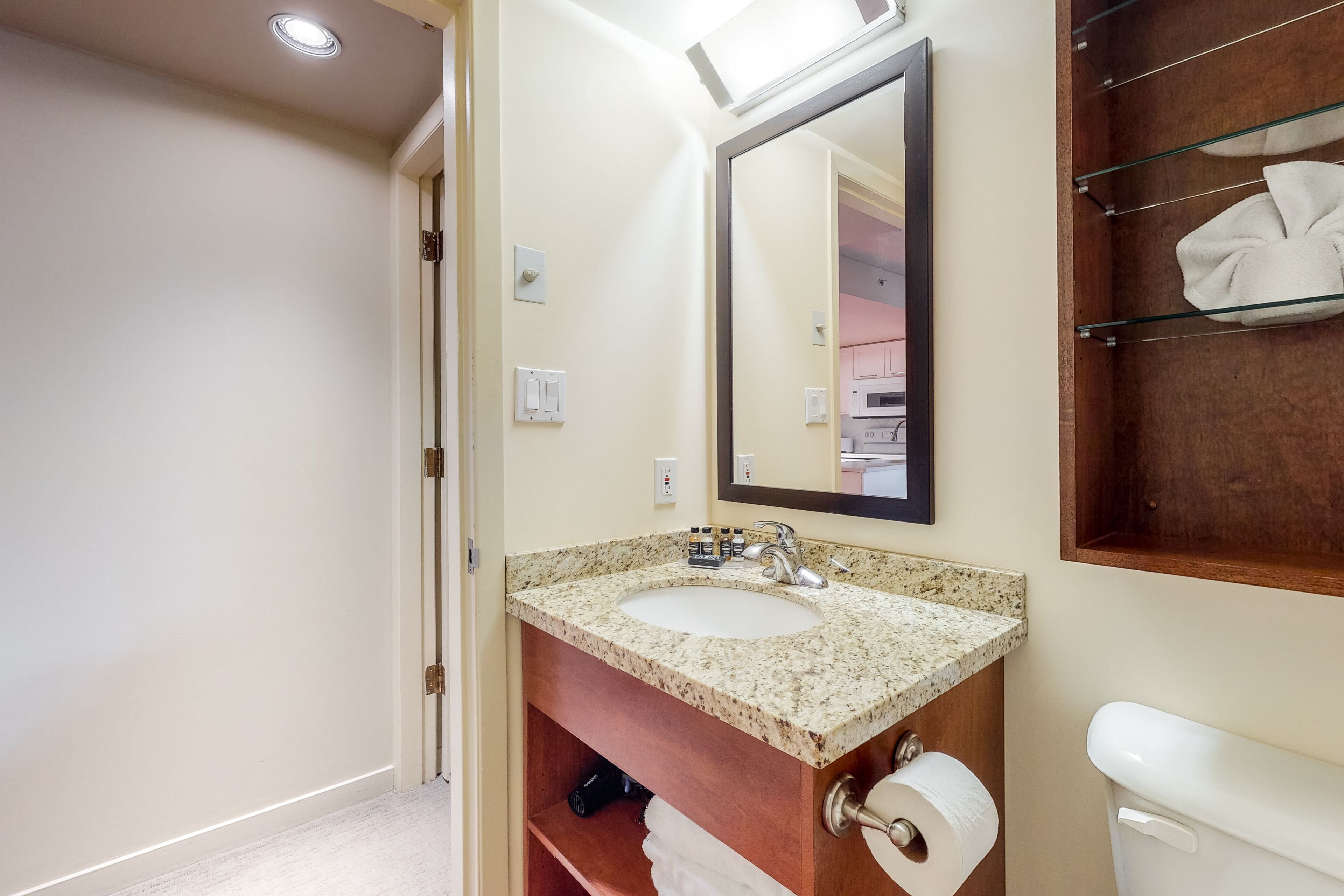 A bathroom with a sink, mirror, towel rack, and toilet.
