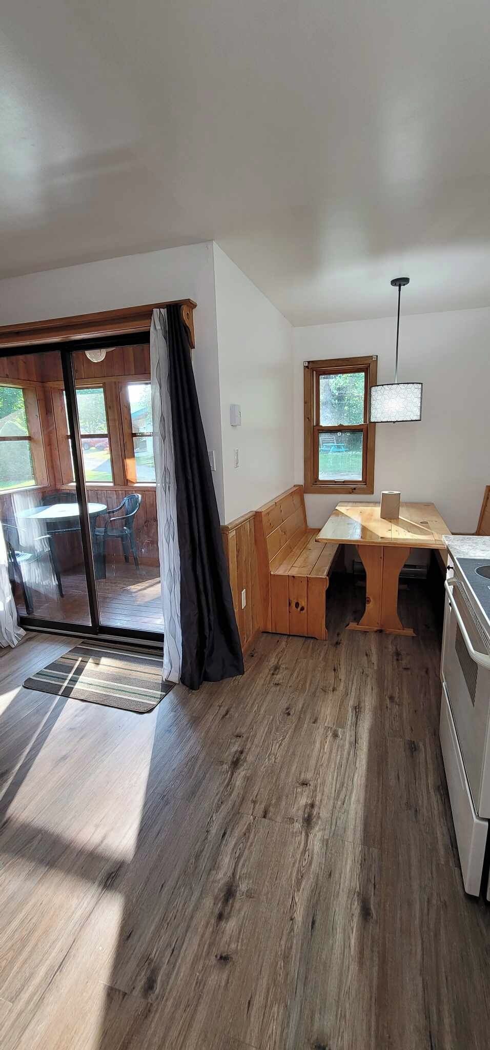 A compact kitchen with a wooden bench, a window, and a stove.