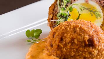 A plated dish with a breaded item, egg, and greens.