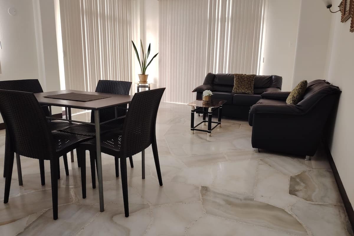 Un salon moderne comprenant une table à manger, des chaises, un canapé et une table basse.
