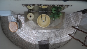 A bathroom with a mosaic floor, a toilet, a sink, and two yellow basins.