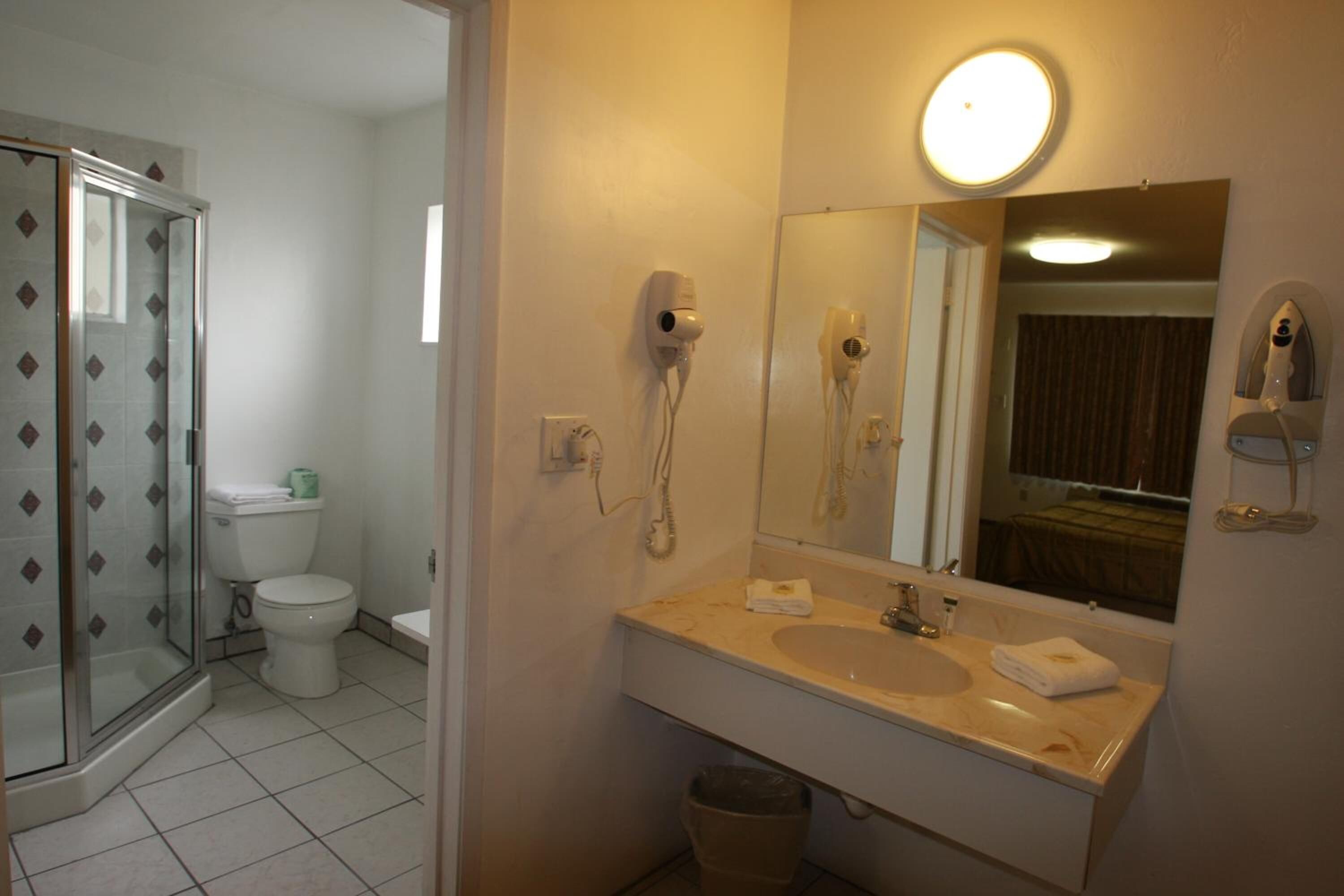 A bathroom with a shower, toilet, and sink.