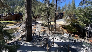 A lodge with outdoor seating and a view of a forested area. - River Ranch Lodge & Restaurant (Olympic Valley)
