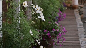 A wooden porch with string lights, potted plants, and a wooden deck. - River Ranch Lodge & Restaurant (Olympic Valley)