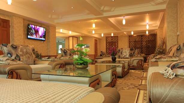 A spacious living room with leather sofas, a glass coffee table, and decorative pillows. - Hotel K Yangon (Yangon)