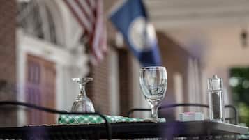 A table with a glass, a salt shaker, and a pepper shaker.