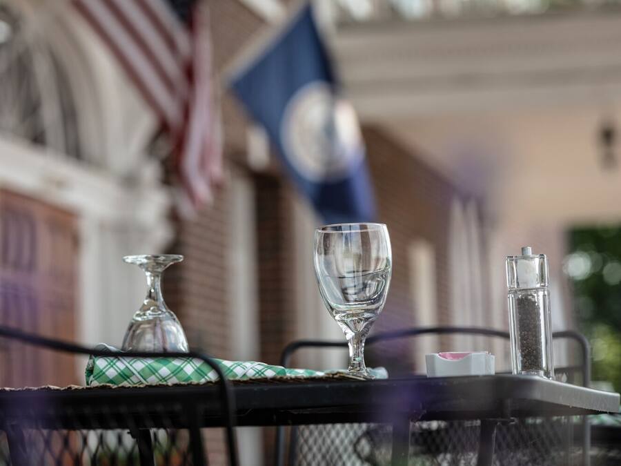 A table with a glass, a salt shaker, and a pepper shaker.