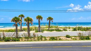A coastal road with palm trees and a parking lot leading to the beach. - Studio 1 Motel (Daytona Beach)