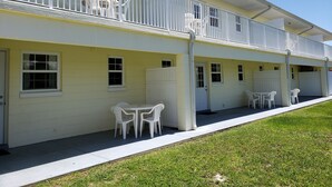 A two-story building with white railings, multiple windows, and outdoor seating areas. - Studio 1 Motel (Daytona Beach)