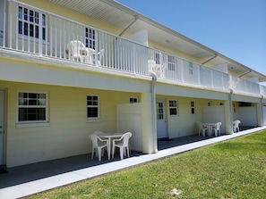 A two-story building with white railings, multiple windows, and outdoor seating areas. - Studio 1 Motel (Daytona Beach)