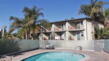 Een buitenzwembad, ligstoelen bij het zwembad