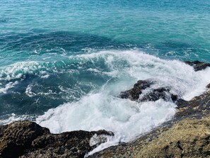 A rocky shoreline with waves crashing against the rocks.