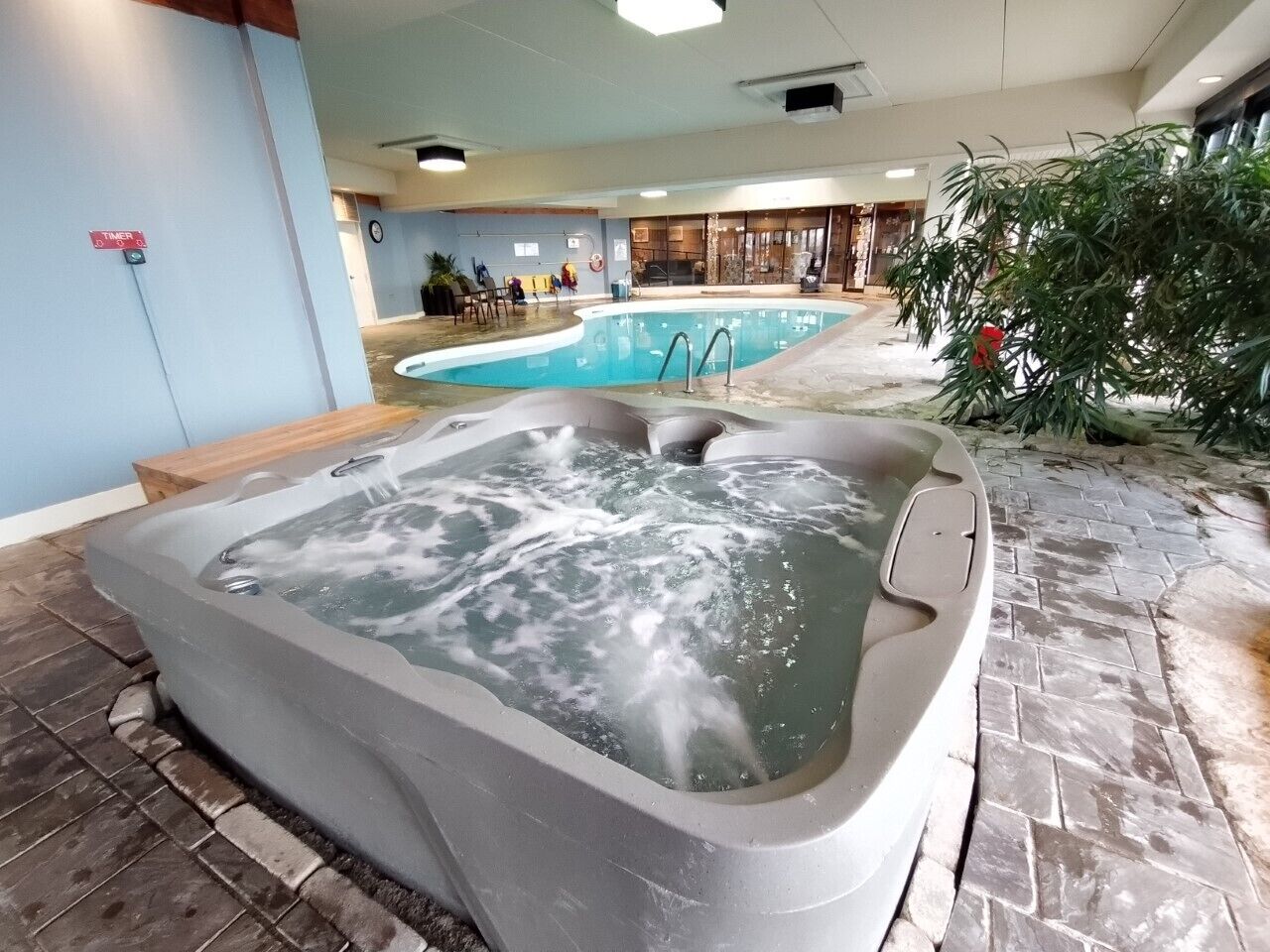 Un jacuzzi con una piscina al fondo.