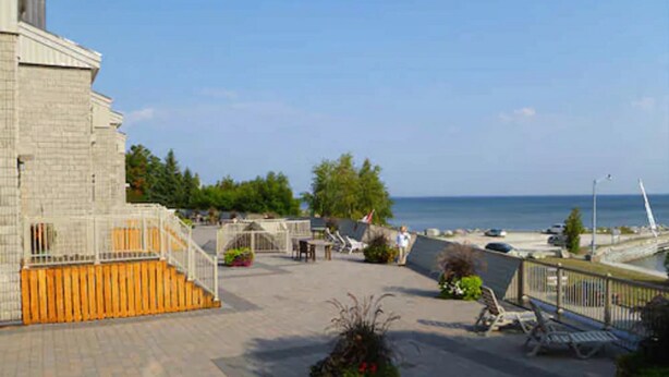 A paved walkway with benches, a small garden area, and a view of the sea. - Royal Harbour Resort (The Blue Mountains)