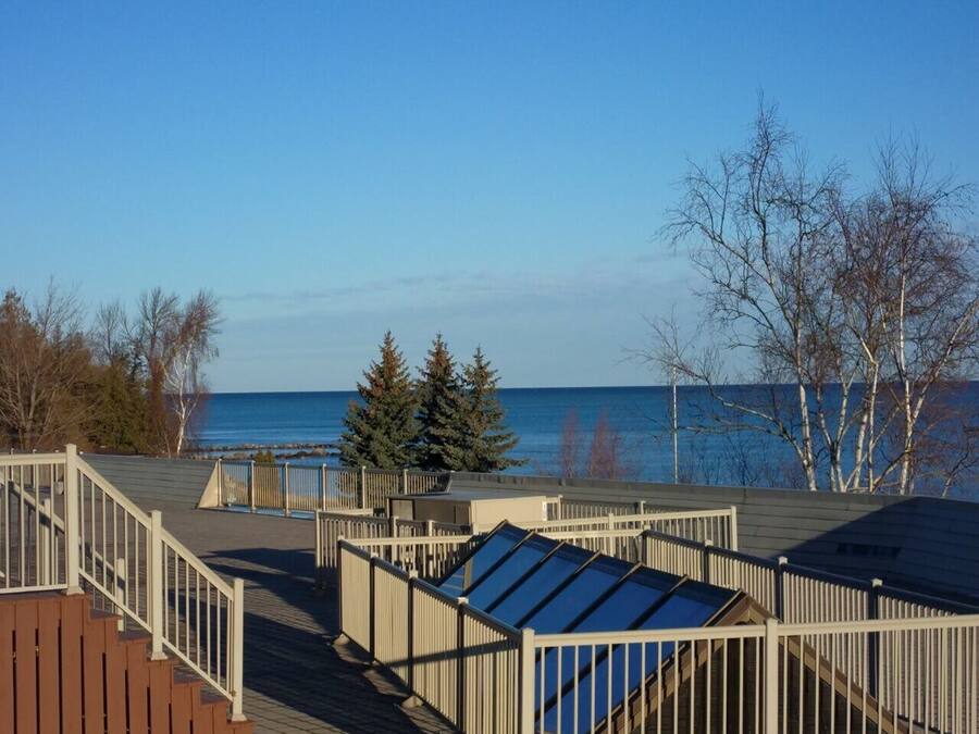 Une terrasse avec vue sur l’eau, des rampes en bois et un escalier.