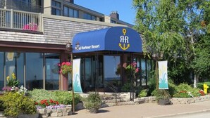 A waterfront building with a blue awning displaying the logo 'AR' and 'Royal Harbour Resort'. - Royal Harbour Resort (The Blue Mountains)
