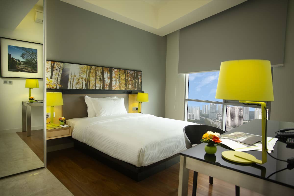 Ein modernes Hotelzimmer mit einem großen Bett, zwei Nachttischen mit Lampen, einem Schreibtisch mit Stuhl und einem großen Fenster mit Blick auf die Stadt.