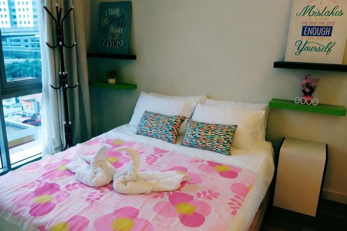 A hotel room with a bed, pillows, a window, and a wall with a sign.