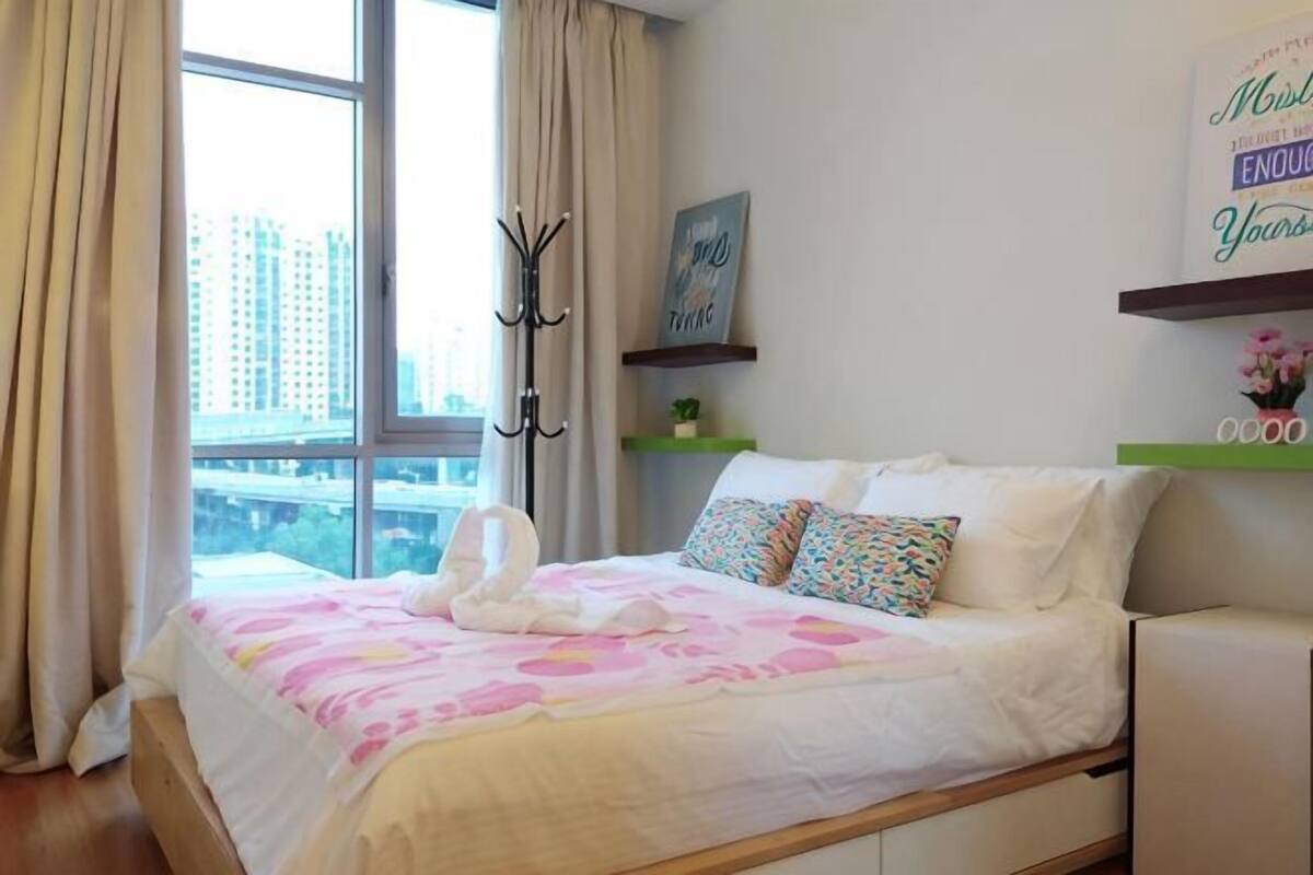 Ein Schlafzimmer mit Bett, Kleiderhaken, einem Fenster und Blick auf die Stadt.