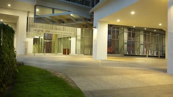 Moderni sisäänkäynti, jonka yläpuolella on kyltti, jossa lukee: ”Signature Suites & Residences”.