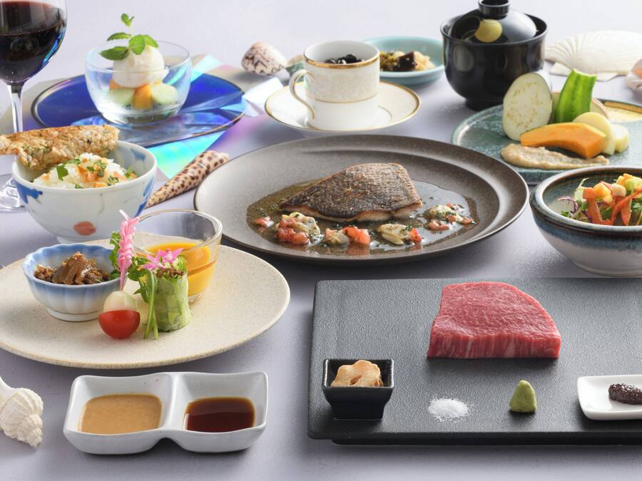 A variety of dishes including sushi, sashimi, and a steak, suggesting a Japanese dining experience.