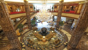 A grand lobby with a central seating area, multiple floors, marble columns, and a large chandelier. - Imabari Kokusai Hotel (Imabari)