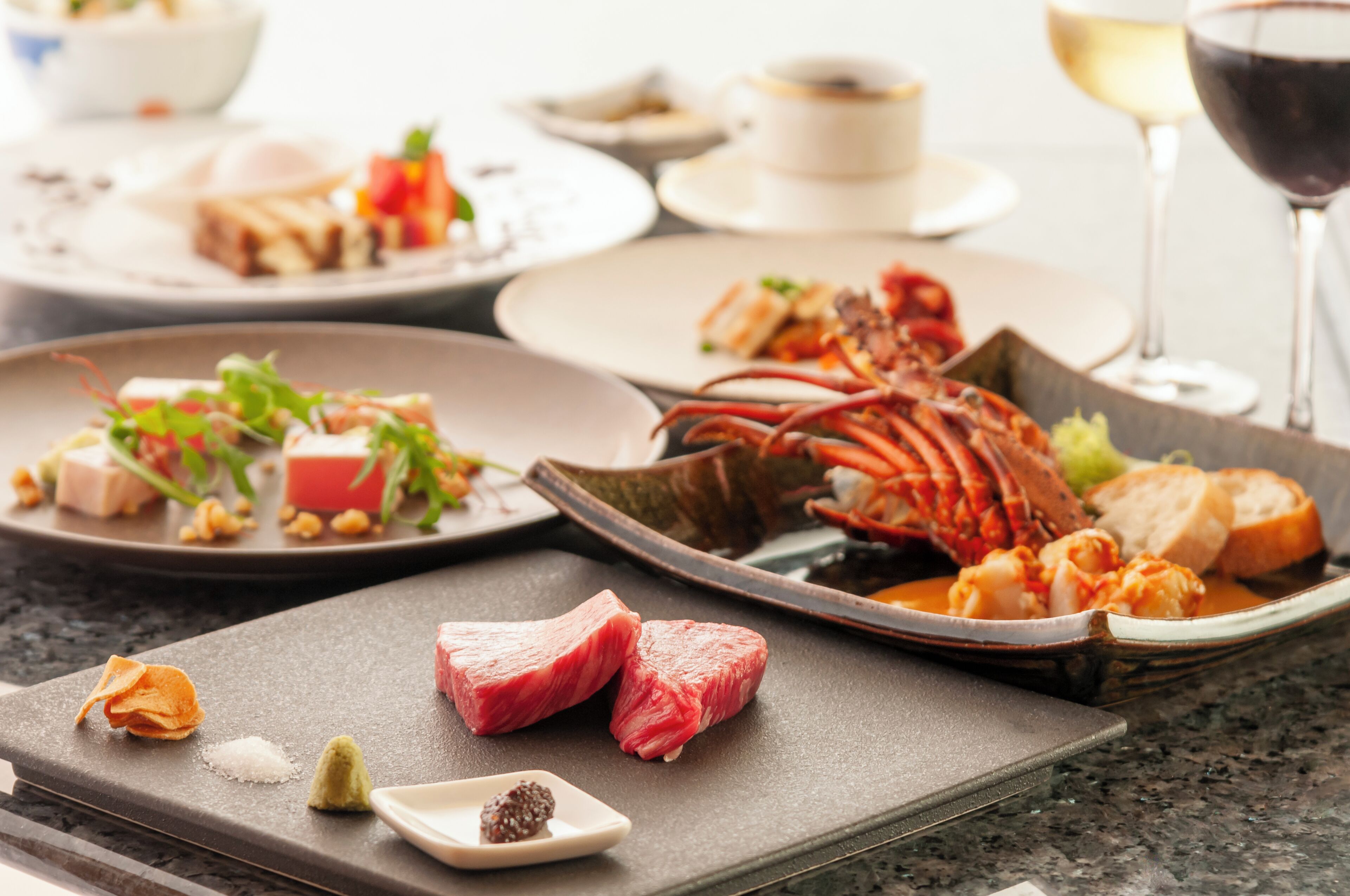 Una variedad de platos en una mesa, incluyendo mariscos, carne y verduras, lo que sugiere un ambiente para comer.