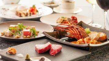 A variety of dishes on a table, including seafood, meat, and vegetables, suggesting a dining setting.