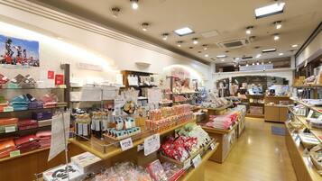 Una tienda bien iluminada con diversos productos en estantes y mostradores, incluyendo artículos envasados y productos para el hogar.
