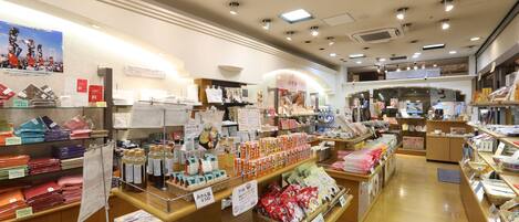 A well-lit store with various products on shelves and counters, including packaged goods and household items.