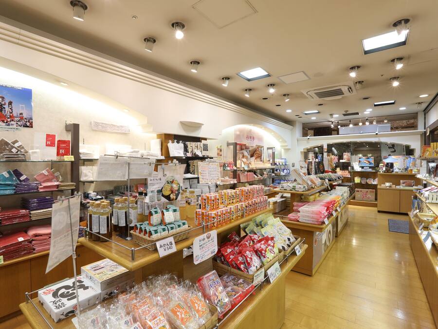 Una tienda bien iluminada con diversos productos en estantes y mostradores, incluyendo artículos envasados y productos para el hogar.
