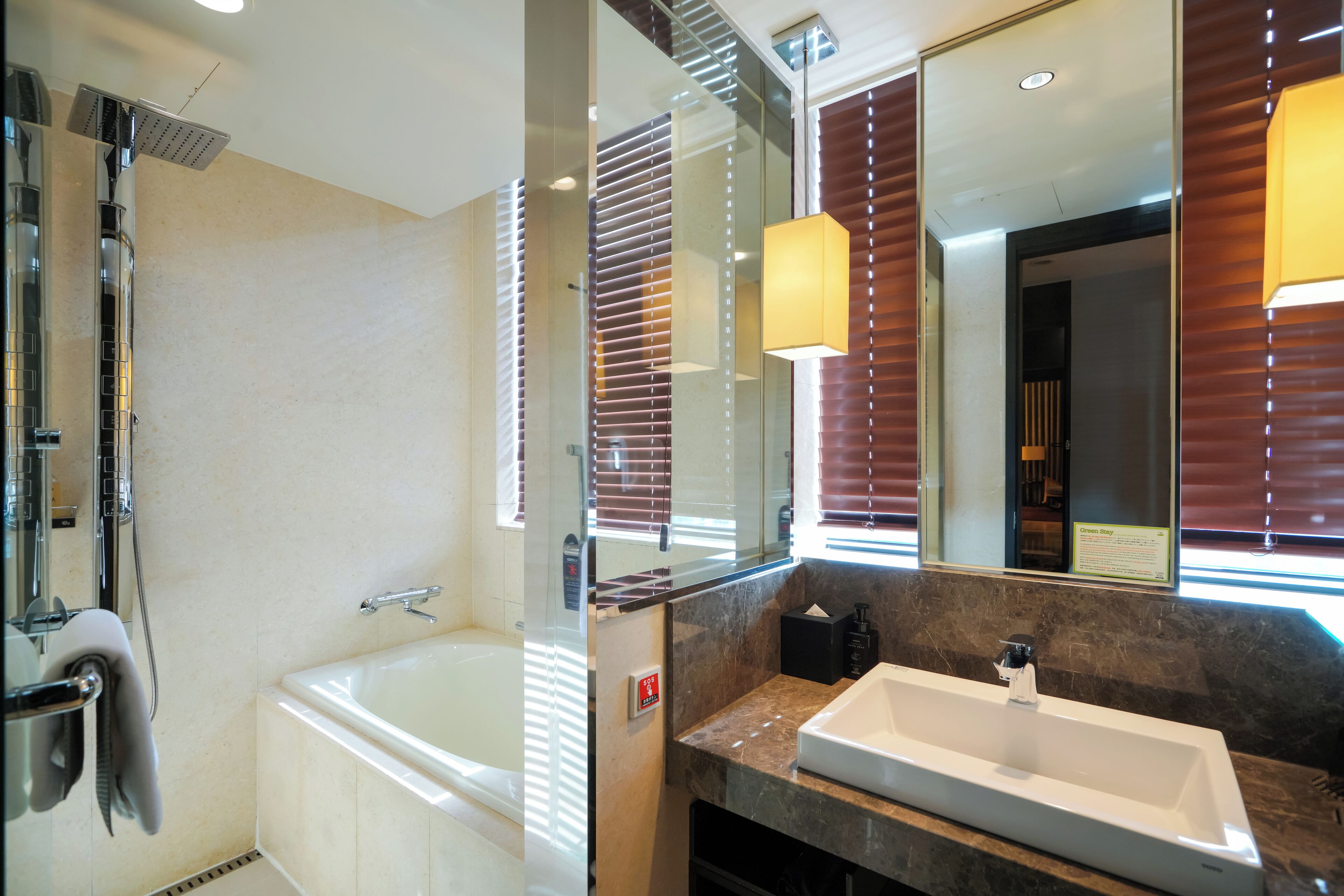 Un baño moderno con bañera, lavamanos y un espejo grande.