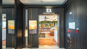 La entrada a un restaurante de diseño moderno, con un cartel y una pantalla digital.