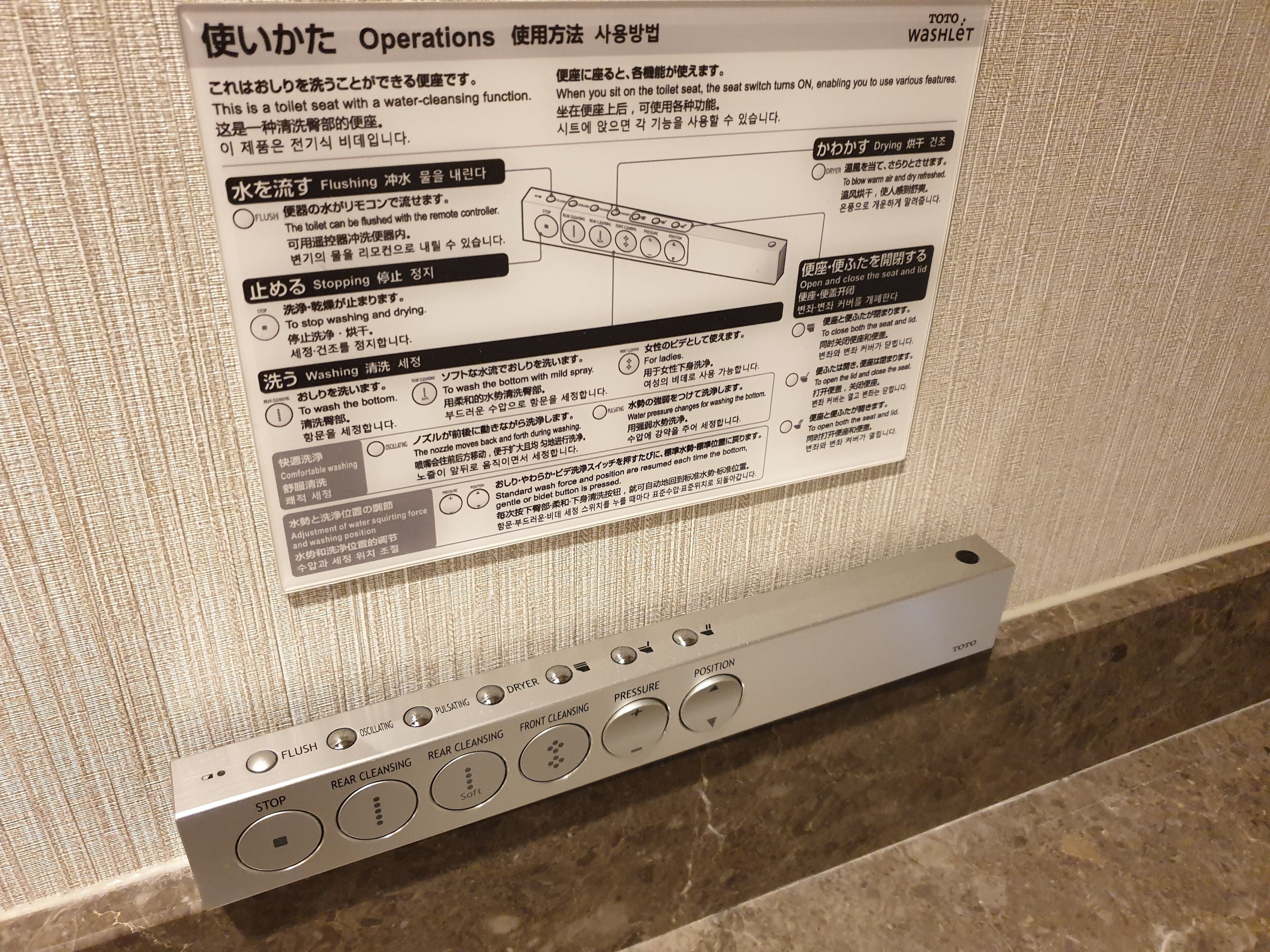 Panel de control con varios botones para funciones del inodoro, como descarga, parada y diferentes modos de limpieza.
