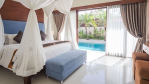 Una camera da letto con un grande letto, una panca blu e vista su una piscina.