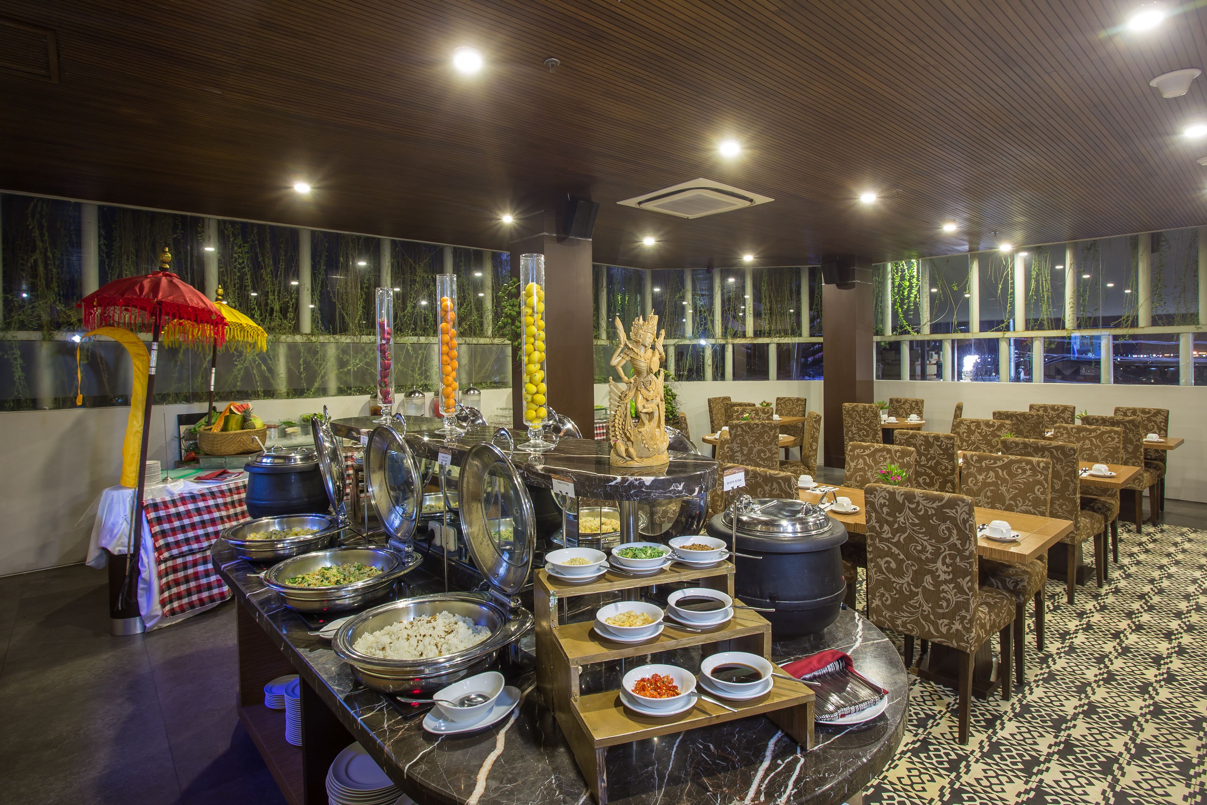 A buffet setup with various food containers and a decorative statue.
