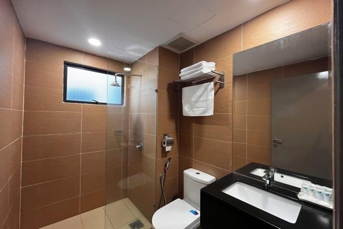 A modern bathroom with a shower, toilet, and dual sinks.
