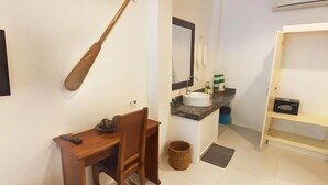 Une petite salle de bain comprenant un lavabo, un miroir et une petite étagère.