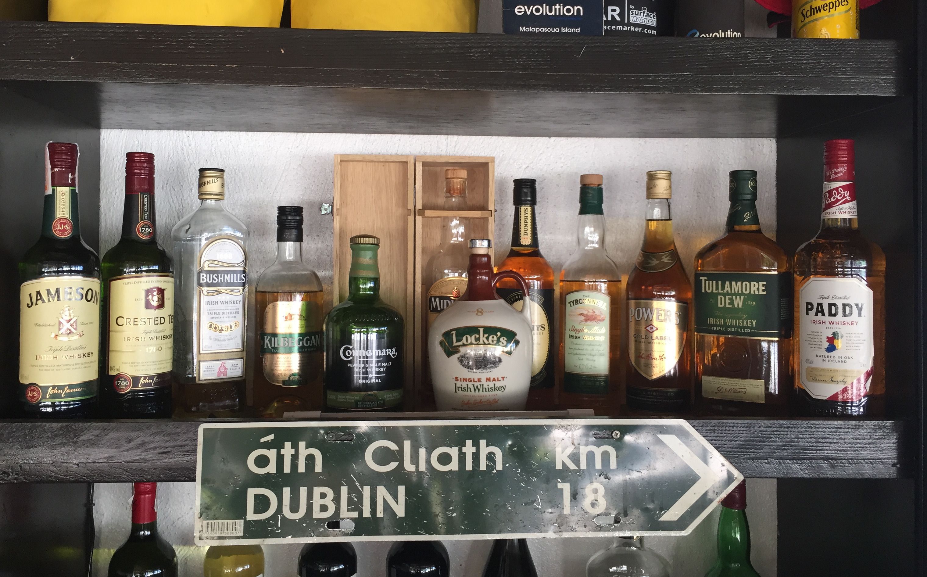 Una estantería con varias botellas de whisky y otras bebidas alcohólicas.