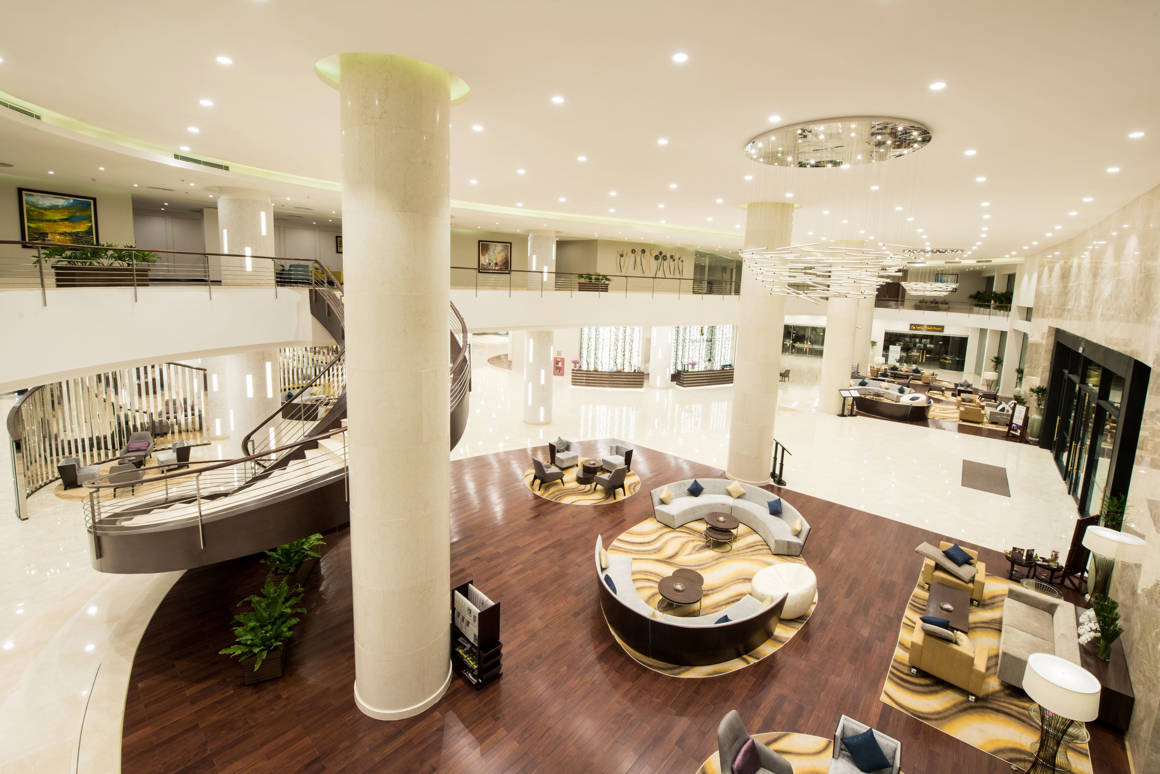 A spacious lobby with a central seating area, multiple levels, and a grand staircase.