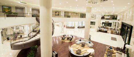 A spacious lobby with a central seating area, multiple levels, and a grand staircase.