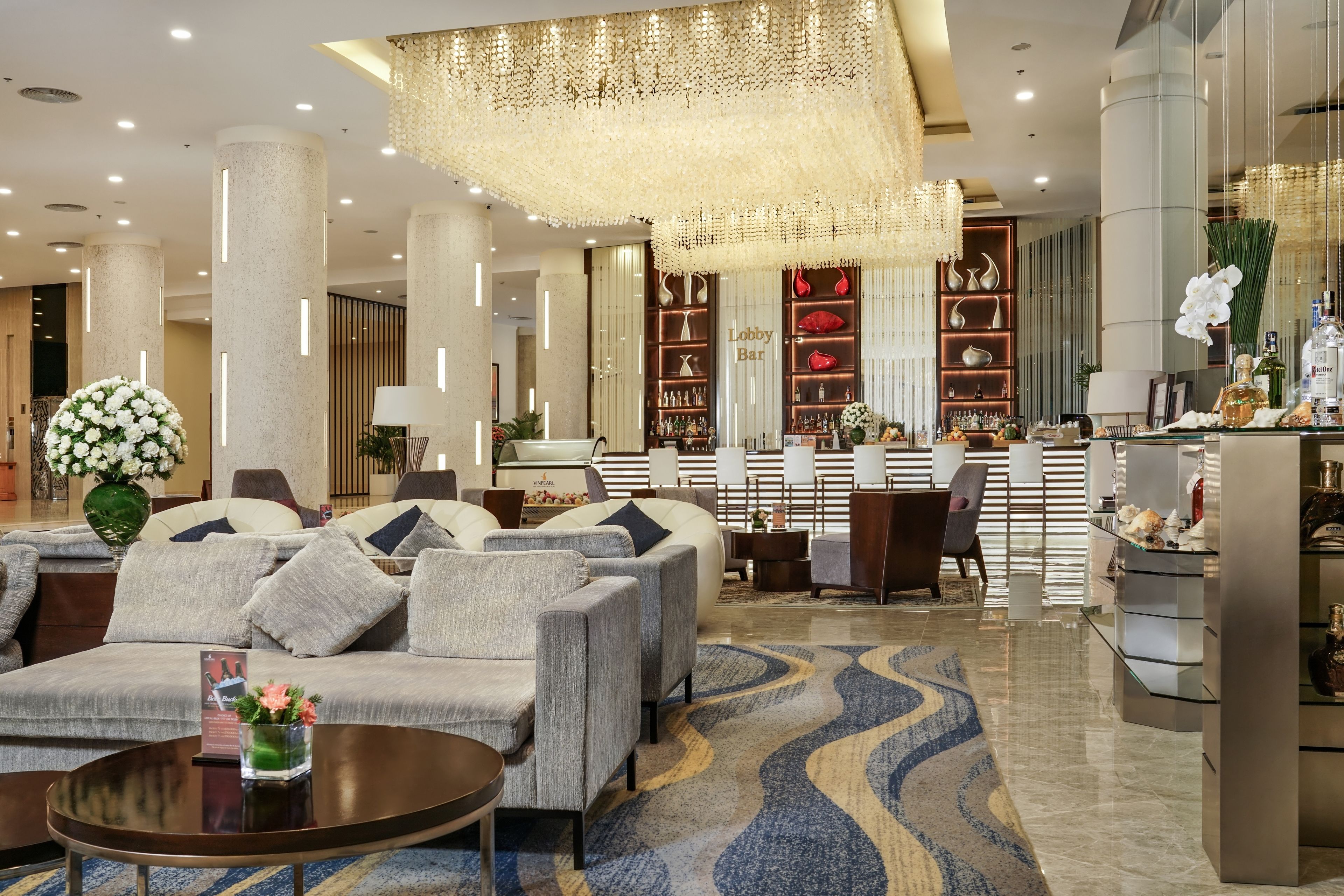 A modern lobby with a sofa set, a coffee table, and a decorative chandelier.