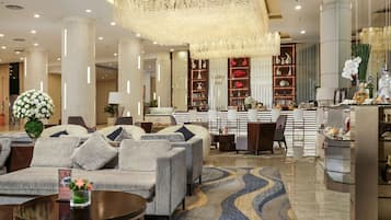 A modern lobby with a sofa set, a coffee table, and a decorative chandelier.