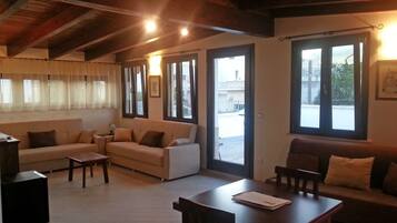 Suite familiare, terrazzo | Area soggiorno | TV a schermo piatto