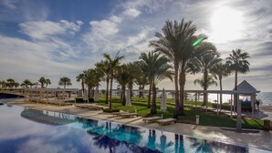 A poolside area with palm trees, lounge chairs, and a gazebo overlooking the sea. - Royal Monte Carlo Sharm El Sheikh - Adults only (Sharm El Sheikh)