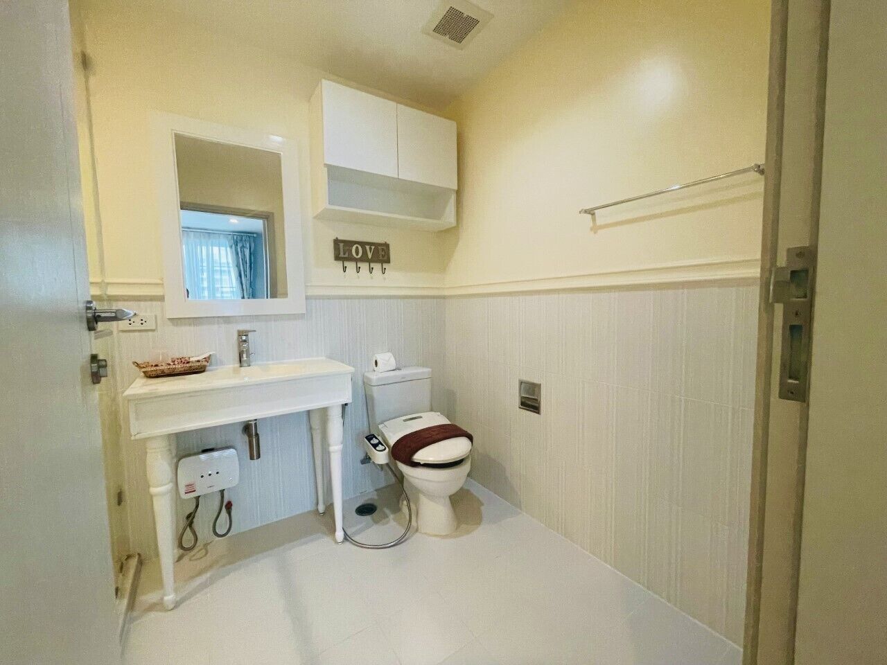 A small, clean bathroom with a toilet, sink, and cabinet.