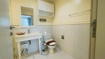 A small, clean bathroom with a toilet, sink, and cabinet.