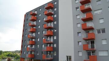 Een modern appartementencomplex met meerdere balkons en een grijze gevel.
