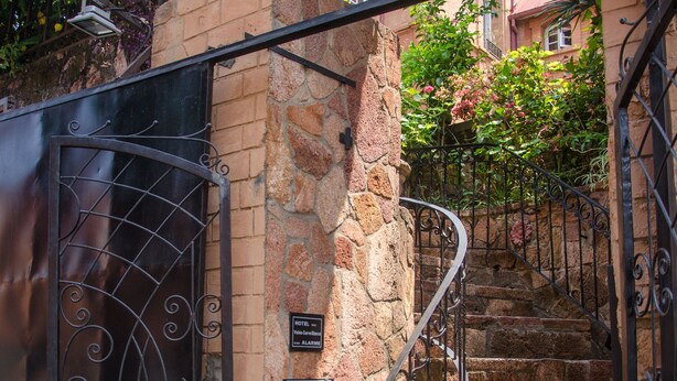 Un escalier en pierre avec des rampes métalliques menant à l’entrée d’un bâtiment.